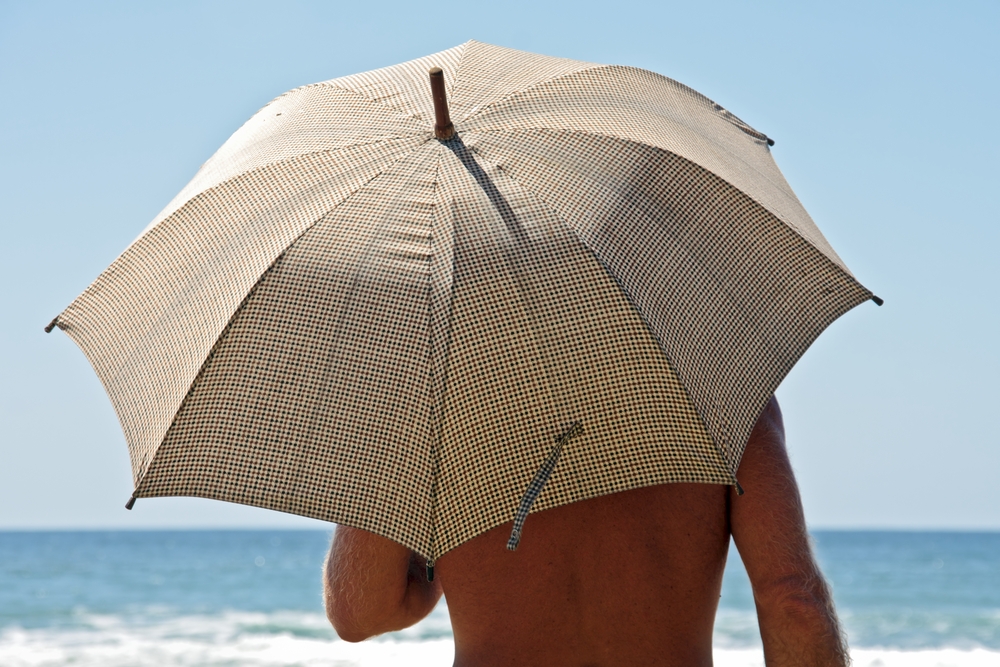 man with umbrella to block the sun