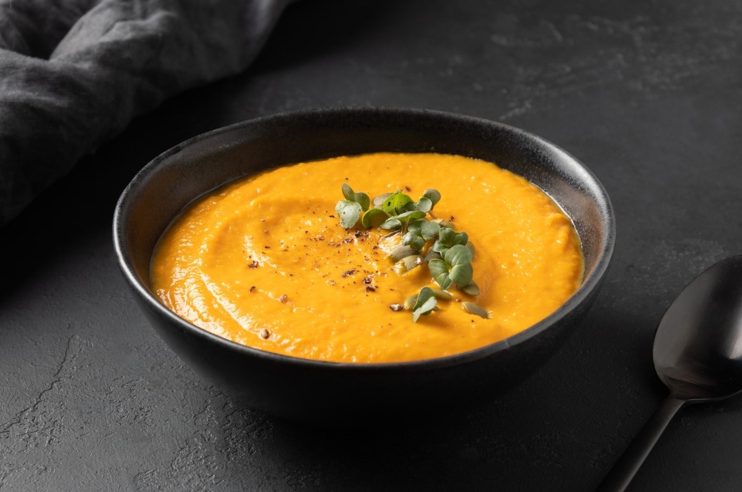 Butternut Squash Soup in a black bowl on a dark table