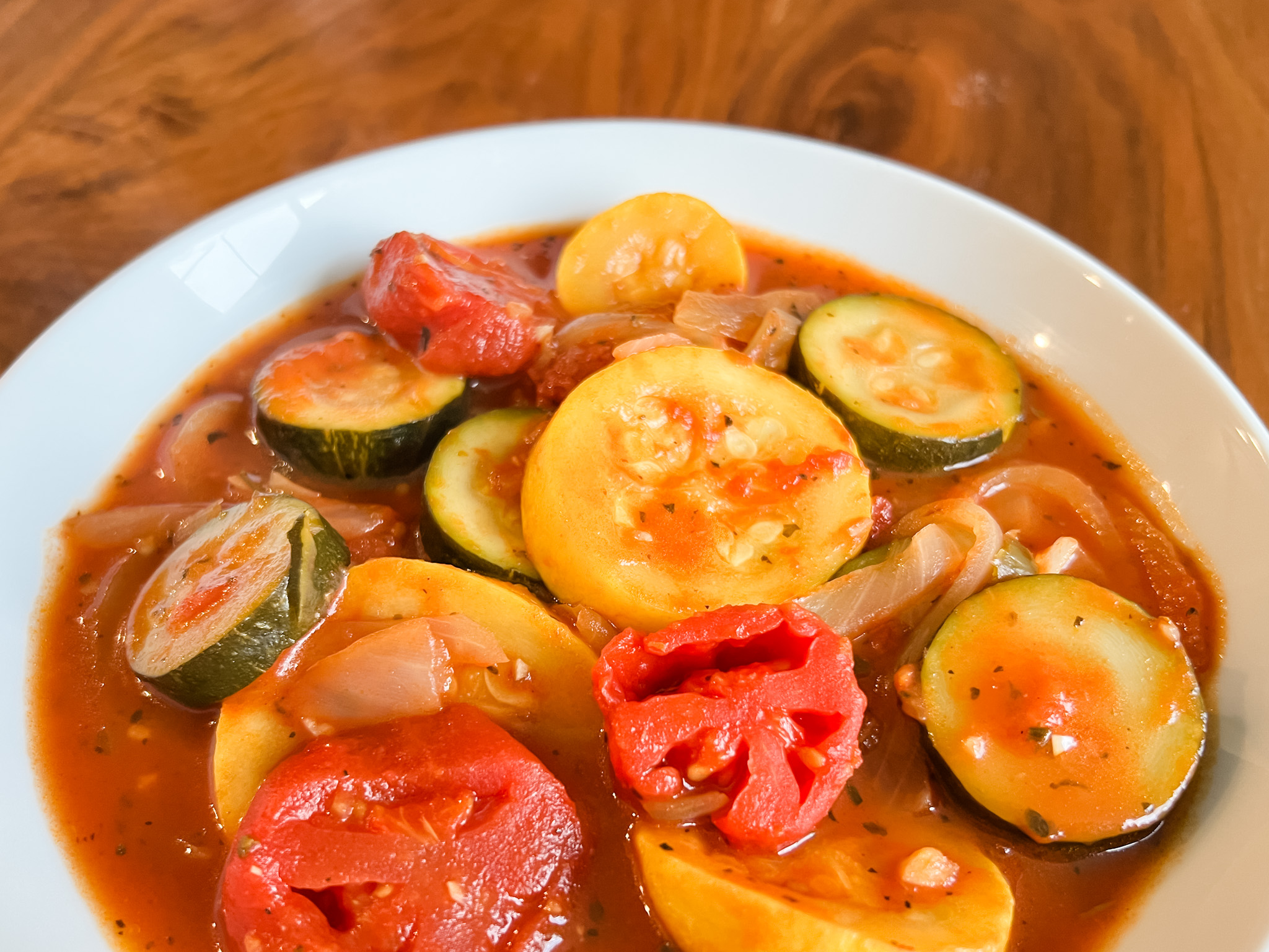 summer Italian squash with tomatoes in a white bowl 
